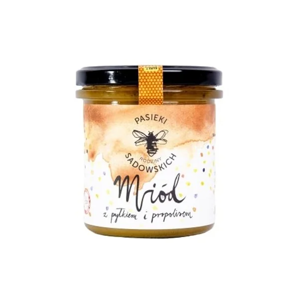 Blütenhonig mit Pollen und Propolis aus der Imkerei der Familie Sadowski in einem großen Glas, zeigt die goldene Farbe und die natürliche Textur des Produkts